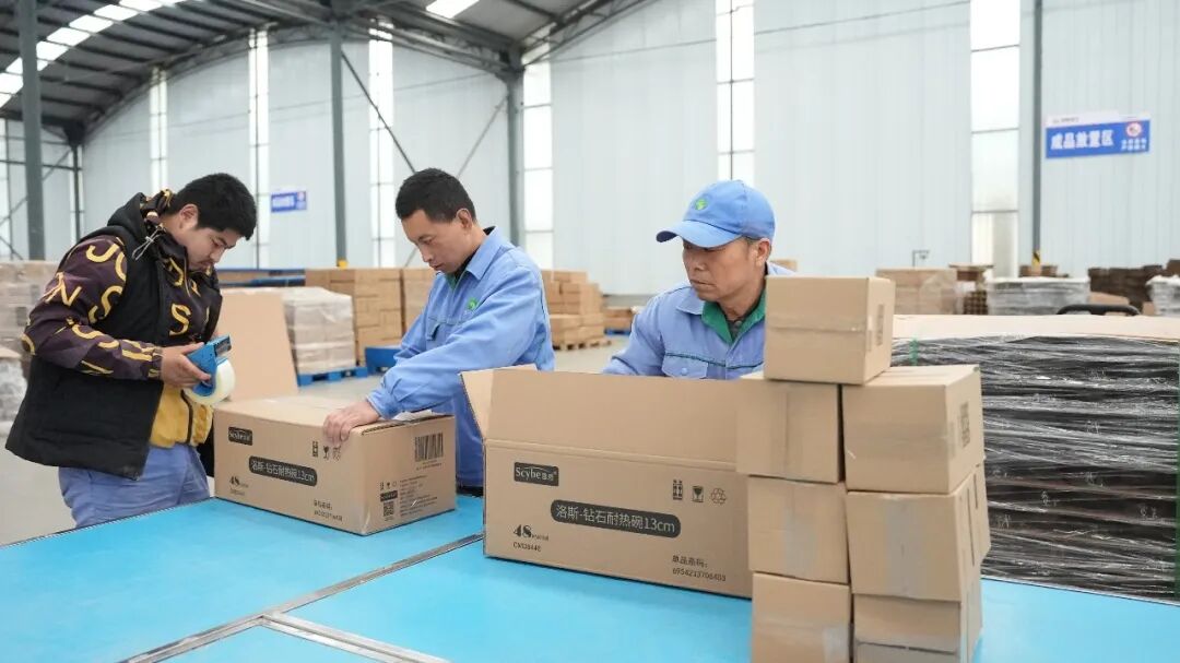 Employee packing glassware for shipment