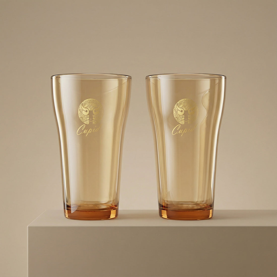 Sienna Glow amber borosilicate glass tumbler with gold Cupid decal available in 12oz and 17oz sizes.SOLA & SIENNA