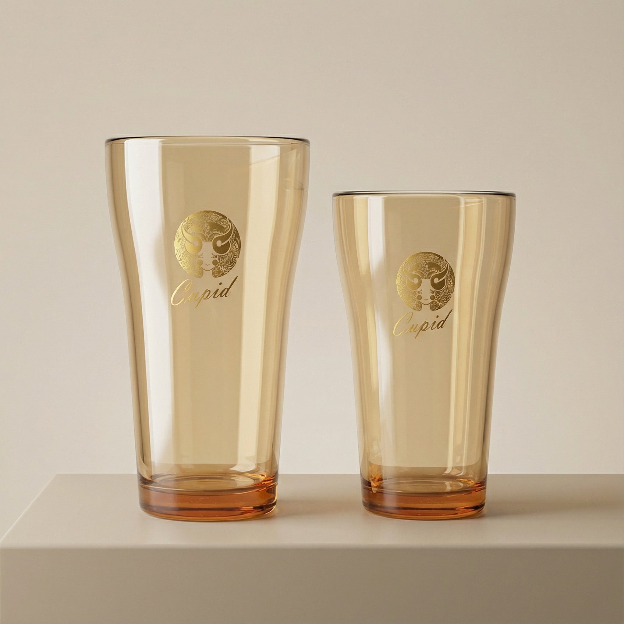 Sienna Glow amber borosilicate glass tumbler with gold Cupid decal available in 12oz and 17oz sizes.SOLA & SIENNA