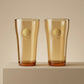 Sienna Glow amber borosilicate glass tumbler with gold Cupid decal available in 12oz and 17oz sizes.SOLA & SIENNA