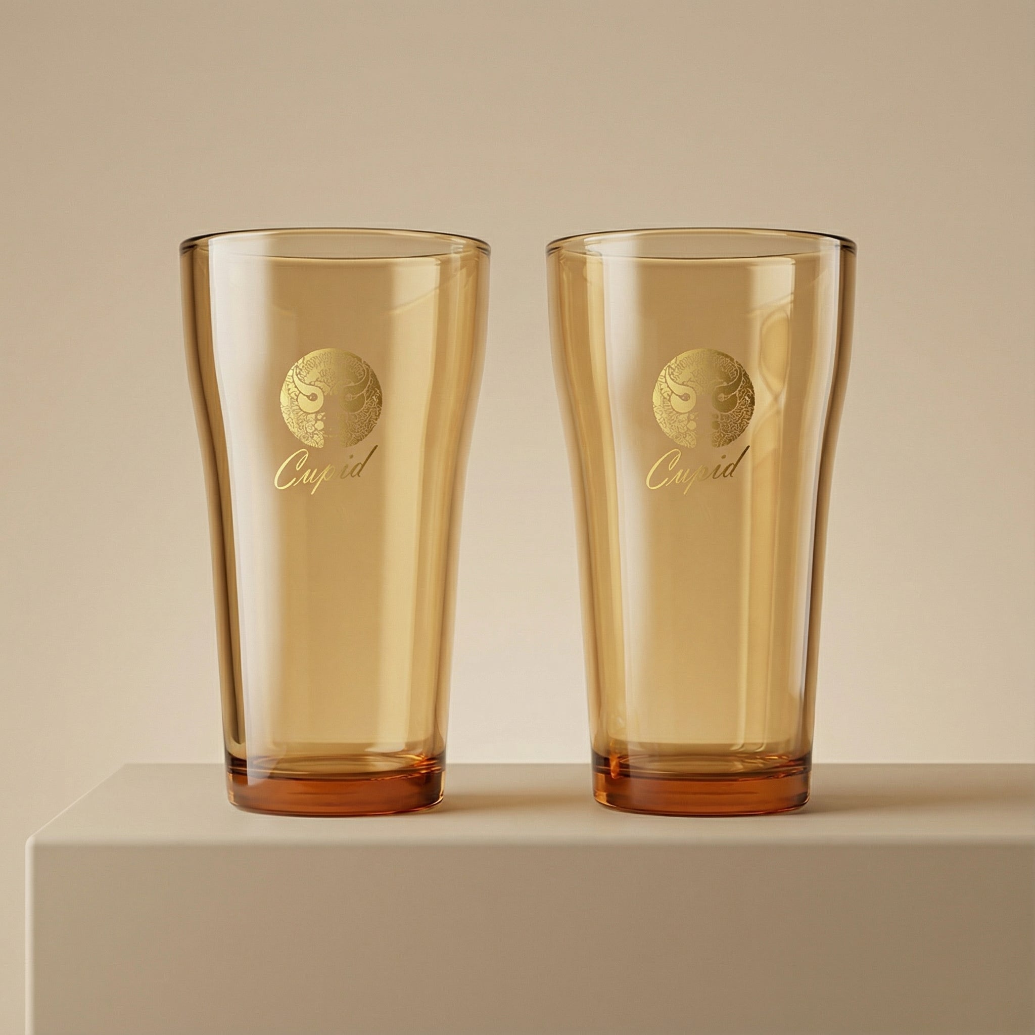 Sienna Glow amber borosilicate glass tumbler with gold Cupid decal available in 12oz and 17oz sizes.SOLA & SIENNA