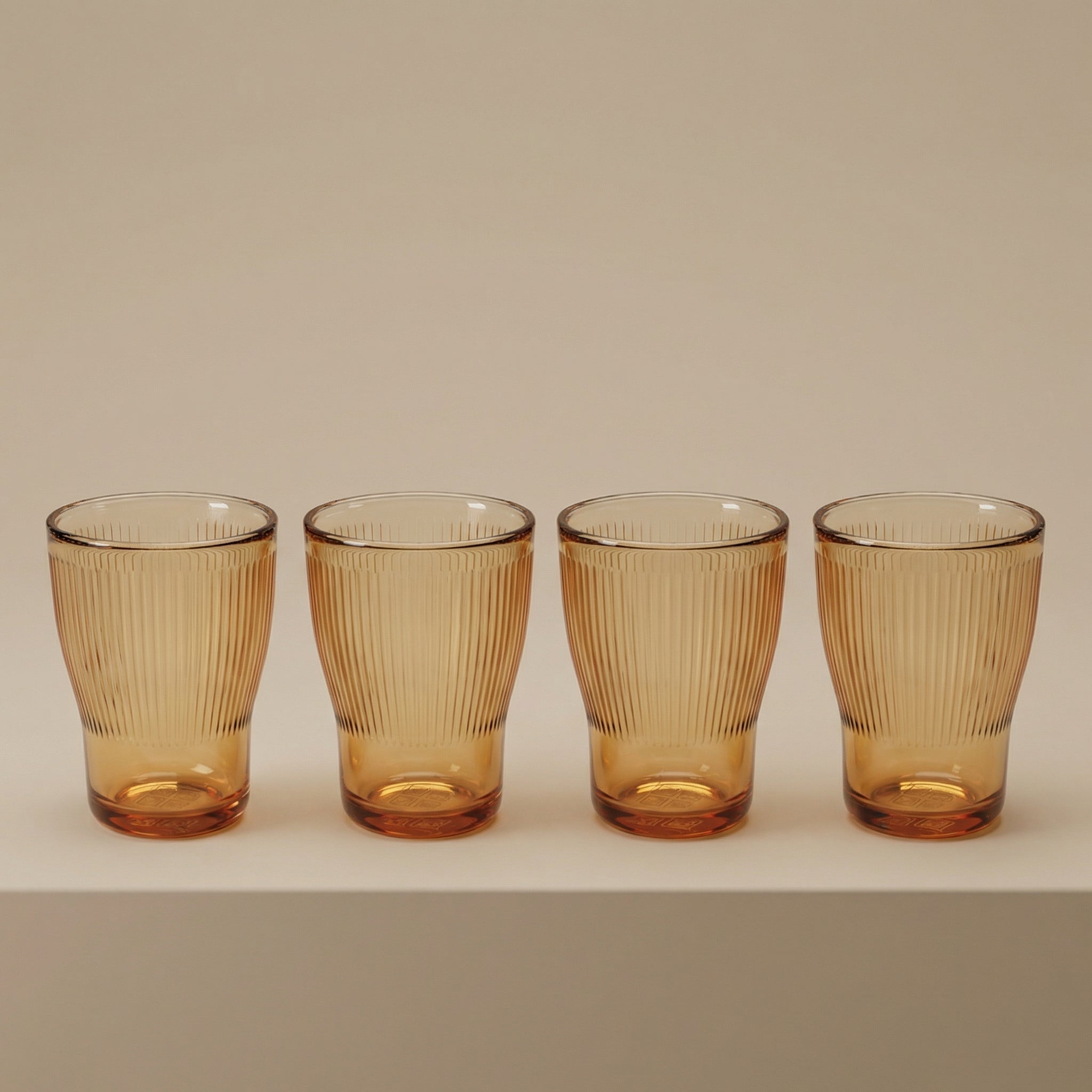 Sienna Glow ribbed amber glass tumbler made of heat-resistant borosilicate glass with elegant vertical texture.SOLA & SIENNA